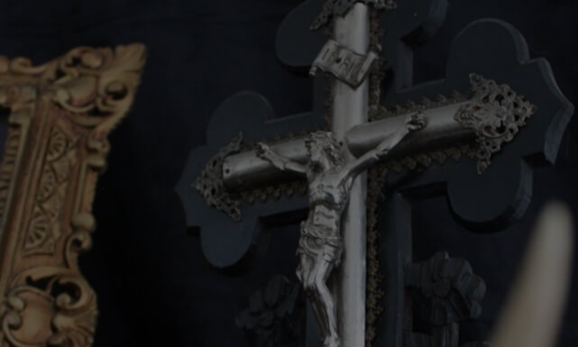 Objets religieux incluant crucifix, statues de saints et chapelets.